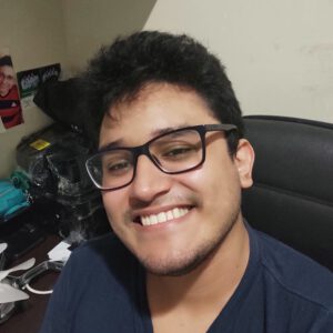 Foto de rosto de Nilberto Jorge. Ele usa uma camisa azul, óculos e está sorrindo